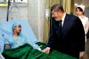 In this image released by the Egyptian Presidency, Egyptian President Mohammed Morsi, right, visits a victim receiving treatment following a train crash in Badrasheen, 40 Kilometers (25 miles) south Cairo at a military hospital in Cairo, Egypt, Tuesday, Jan. 15, 2013. At least 19 people died and more than 100 were injured when two railroad passenger cars derailed just south of Cairo, health officials say. The accident comes less than two weeks after a new transportation minister was appointed to overhaul the rail system, and just two months after a deadly collision between a train and school bus. (AP Photo/Egyptian Presidency)