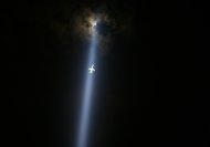 Un aereo vola attraverso il 'Tribute in lights', l'installazione luminosa che ogni anno ricorda le vittime dell'11 settembre a New York con due fasci di luce accesi nel punto dove sorgevano le Torri gemelle