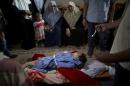 Palestinian mourners weep over the bodies of two-year-old Rahaf Hassan and her 30-year-old pregnant mother, Noor Hassan, who were killed in an Israeli air strike Sunday morning, during their funeral in the family house south of Gaza city in the Gaza Strip, Sunday, Oct. 11, 2015. In response to renewed rocket fire toward Israel, the military said it carried out airstrikes in Gaza targeting Hamas weapons manufacturing facilities. Ashraf Al-Kidra, a Health Ministry spokesman in Gaza, said a nearby home was struck, which killed Rahaf and Noor and wounded four others including Noor's husband and son. (AP Photo/ Khalil Hamra)