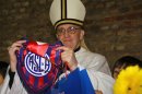 In this March 24, 2011 image released by the San Lorenzo de Almagro soccer team on March 13, 2013, Argentina's Cardinal Jorge Bergoglio holds up a small flag of the San Lorenzo soccer team in Buenos Aires, Argentina. Bergoglio, a San Lorenzo soccer fan, was chosen as Pope on March 13, 2013, the first pope ever from the Americas and the first from outside Europe in more than a millennium. (AP Photo/Club Atletico San Lorenzo de Almagro)