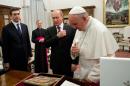 In this photo provided by the Vatican newspaper L'Osservatore Romano, Russian President Vladimir Putin, center, and Pope Francis cross themselves in front of an icon of the Madonna, given to the pontiff by Putin on the occasion of their private audience at the Vatican, Monday, Nov. 25, 2013. Putin presented Francis with an image of the icon of the Madonna of Vladimir, an important religious icon for the Russian Orthodox faithful. After they exchanged the gifts, Putin asked Francis if he liked it, and Francis said he did. Putin then crossed himself and kissed the image, and Francis followed suit. They met privately for 35 minutes Monday evening in the pope's private library. (AP Photo/L'Osservatore Romano, ho)