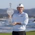 Brandt Snedeker poses with his trophy on the 18th green of the Pebble Beach Golf Links after winning the AT&T Pebble Beach Pro-Am golf tournament Sunday, Feb. 10, 2013, in Pebble Beach, Calif. Snedeker won the tournament after shooting a 7-under-par 65 to finish at total 19-under-par. (AP Photo/Eric Risberg)