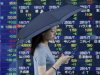 A woman holding a parasol walks past an electronic stock board of a securities firm in Tokyo Friday, Aug. 3, 2012. Japan's Nikkei 225 stock average was down 1.2 percent at 8,553.68 on Friday as Asian stock markets fell after the European Central Bank's policy meeting failed to deliver on bold promises of action to overcome the region's prolonged debt crisis. (AP Photo/Koji Sasahara)