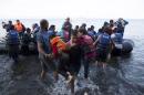 A Syrian refugee carries two children moments after arriving on a dinghy on the Greek island of Lesbos