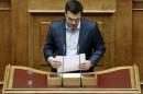 Tsipras arranges his notes after his speech during a parliamentary session in Athens