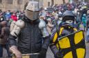 Protesters clad in improvised protective gear prepare for a clash with police in central Kiev, Ukraine, Monday, Jan. 20, 2014. After a night of vicious streets battles, anti-government protesters and police clashed anew Monday in the Ukrainian capital Kiev. (AP Photo/Evgeny Feldman)