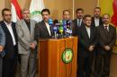 ADDS NAME OF SPEAKER AT PODIUM - Falah al-Qaisi, directly at microphones, and other Baghdad provincial council members, speak to the media in Baghdad, Saturday, July 26, 2014. Gunmen traveling in 10 black SUVs seized Riyadh al-Adhdah, the head of the Baghdad Provincial Council and a senior Sunni politician who had previously been jailed on terrorism charges from his home in Baghdad on Saturday, police officers said. (AP Photo/Karim Kadim)