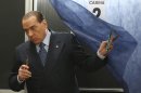 Former Premier Silvio Berlusconi exits a booth as he votes in a polling station in Milan, Italy, Sunday, Feb. 24, 2013. Italy votes in a watershed parliamentary election Sunday and Monday that could shape the future of one of Europe's biggest economies. (AP Photo/Antonio Calanni)