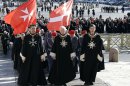 Members of the Knights of Malta walk in procession towards St. Peter's Basilica during a celebration to mark the 900th anniversary of the Order of the Knights of Malta, at the Vatican, Saturday, Feb. 9, 2013. The order traces its history to the 11th century with the establishment of an infirmary in Jerusalem that cared for people of all faiths making pilgrimages to the Holy Land. It is the last of the great lay chivalrous military orders like the Knights Templars that combined religious fervor with fierce military might to protect and expand Christendom from Islam's advance during the Crusades. In February 1113, Pope Paschal II issued a papal bull recognizing the order as independent from bishops or secular authorities, reason for Saturday's anniversary celebrations at the Vatican. (AP Photo/Gregorio Borgia)