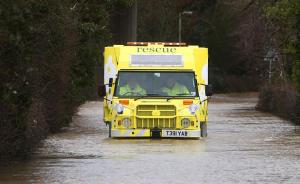 An amphibious rescue vehicle drives through floodwaters …