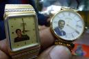A man holds watches bearing the portrait of late Iraqi dictator Saddam Hussein, on December 9, 2013 at a market in Baghdad