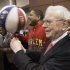 Berkshire Hathaway Chairman and CEO Warren Buffett, right, is watched by Detroit Lions defensive tackle Ndamukong Suh, left, as he is assisted by Harlem Globetrotter Chris “Handles” Franklin in spinning a basketball in Omaha, Neb., Saturday, May 4, 2013, before holding the Berkshire Hathaway shareholders meeting. Tens of thousands attend Berkshire Hathaway shareholder meeting to hear Warren Buffett and Charlie Munger answer questions for more than six hours. No other annual meeting can rival Berkshire's, which is known for its size, the straight talk Buffett and Munger offer and the sales records shareholders set while buying Berkshire products. (AP Photo/Nati Harnik)