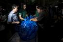 The body of slain British tourists, Hannah Witheridge, wrapped in plastic sheet, is carried at a forensic police facility in Bangkok, Thailand, Tuesday, Sept. 16, 2014. Police on the scenic resort island of Koh Tao in southern Thailand conducted a sweep of hotels and workers' residences Tuesday searching for clues into the slayings of two British tourists whose nearly naked, battered bodies were found on a beach a day earlier.(AP Photo/Sakchai Lalit)