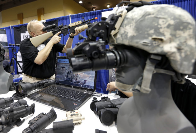 Allen Harding, of Armasight, demonstrates his products Tuesday, March 12, 2013 at the Border Security Expo in Phoenix. More than 180 companies are exhibiting their security products despite automatic spending cuts that are affecting every federal government agency due to the government sequestration. (AP Photo/Matt York)