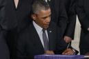 U.S. President Barack Obama signs the Defending Public Safety Employees' Retirement Act and Trade Preference Extension Act of 2015 during ceremony in White House in Washington
