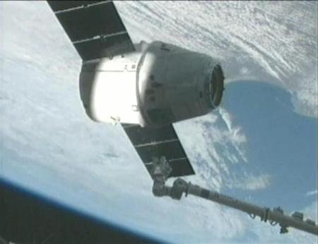 The SpaceX Dragon capsule is captured by the crew of the International Space Station using its robotic arm in this screen capture from NASA handout video released March 3, 2013. REUTERS/NASA/Handout