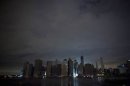 A largely unlit downtown Manhattan stands under a night sky due to a power blackout caused by Hurricane Sandy in New York