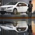 FILE - In this file photo taken on April 20, 2011, a GM Chevrolet division employee are reflected in a floor as she stands next to a Chevrolet Volt model on display at the 14th Shanghai International Auto Show in Shanghai, China. General Motors Co. agreed Tuesday, Sept. 20, to deepen cooperation with its flagship Chinese partner on development of electric vehicle know how amid pressure from Beijing to hand over proprietary technology. (AP Photo/Andy Wong, File)