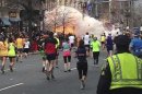 Maratoneti a Boston verso la linea del traguardo mentre scoppia l'esplosione