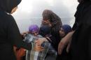 Palestinians mourn outside a morgue in Gaza City