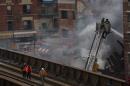 New York City firefighters examine the rubble at an apparent building explosion fire and collapse in the Harlem section of New York