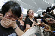 Relatives of the victims in Saturday's train crash talk to the media as they hold a banner demanding pursuit of truth of the accident during a protest at Wenzhou South Railway Station in Wenzhou, east China's Zhejiang Province, Wednesday, July 27, 2011. The Chinese government on Tuesday ordered a two-month, nationwide safety campaign for its railway system after a collision between two bullet trains killed dozens of people. (AP Photo/Kyodo News) JAPAN OUT, MANDATORY CREDIT, NO LICENSING IN CHINA, FRANCE, HONG KONG, JAPAN AND SOUTH KOREA