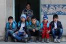 Schoolchildren pose after they registered in a school and received their new school bags in Mosul