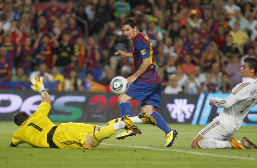 FC Barcelona's Lionel Messi from Argentina, centre, scores his goal after facing Real Madrid's goalkeeper Iker Casillas, left, and Cristiano Ronaldo from Portugal, right, during a second leg Spanish Supercup soccer match at the Camp Nou stadium in Barcelona, Spain, Wednesday, Aug. 17, 2011. (AP Photo/Andres Kudacki)