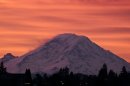 FILE -- Mount Rainer is seen at dawn in this Jan. 2, 2012, file photo, from Seattle, some 50 miles away from the national park. As the search for four people on the slopes of Mount Rainier stretches into its second week, experts say the rewards for the hearty few who attempt the summit of the 14,411-foot heavily glaciated volcano in winter are great, as are the dangers. (AP Photo/Elaine Thompson, File)