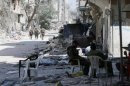 Soldiers of the Syrian government forces patrol in a devastated street on July 31, 2013 in the city of Homs