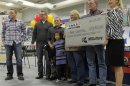 The Hill family holds an oversized check presented by Missouri Lottery director May Scheve during a news conference at the North Platte High School in Dearborn
