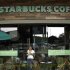 A customer with a cup of coffee leaves the new Starbucks store in San Jose