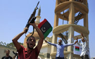 Un grupo de libios celebra la liberación del distrito de Qasr Bin Ghashir en Trípoli, la capital de Libia, el sábado 27 de agosto de 2011. (Foto AP/Sergey Ponomarev)
