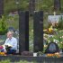 In this Monday, July 25, 2011 photo, Vladimir Gavriushin sits at the grave he built for his daughter Yelena in a cemetery outside Vilnius, Lithuania. Yelena was one of the nearly 3,000 people killed on Sept. 11, 2001. Gavriushin has buried rocks from ground zero under these tombstone towers, far from the place Yelena died _ a place he can no longer afford to visit. And so, as the 10-year anniversary of the terrorist attacks approaches, he mourns for her here, at his own ground zero. He remembers frantically calling his daughter that day amid the terrified crowds in Brooklyn, where he was at the time: "She never answered." (AP Photo/Mindaugas Kulbis)