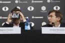 Chess world champion Magnus Carlsen, of Norway, left, looks through a virtual reality viewer while his challenger, Sergey Karjakin, of Russia, looks on during a news conference to promote the World Chess Championship in New York, Thursday, Nov. 10, 2016. The championship, which will also be broadcast live in 360 degrees, starts Nov. 11, 2016, in New York. (AP Photo/Seth Wenig)