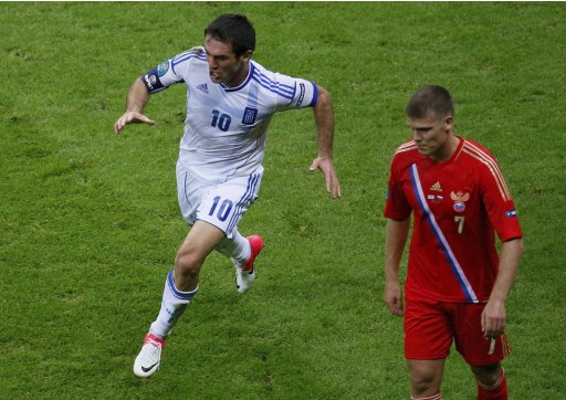 Greece's Karagounis runs past Russia's Denisov as celebrates goal during Euro 2012 soccer match in Warsaw