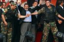 Egypt's Islamist President-elect Mohamed Mursi waves to his supporters while surrounded by his members of the presidential guard in Cairo's Tahrir Square