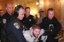 California Highway Patrol Officers carry out a protester after he refused to leave the state Capitol in Sacramento, Calif., Monday, March 5, 2012. Dozens of protesters were arrested after repeated warnings, capping off a day of protests over cuts to higher education. (AP Photo/Rich Pedroncelli)
