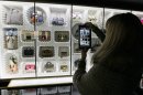 A visitor takes a picture of fashion creations displayed at the Louis Vuitton-Marc Jacobs exhibit in the Art Decoratifs Museum in Paris, Thursday, March 8, 2012. (AP Photo/Francois Mori)
