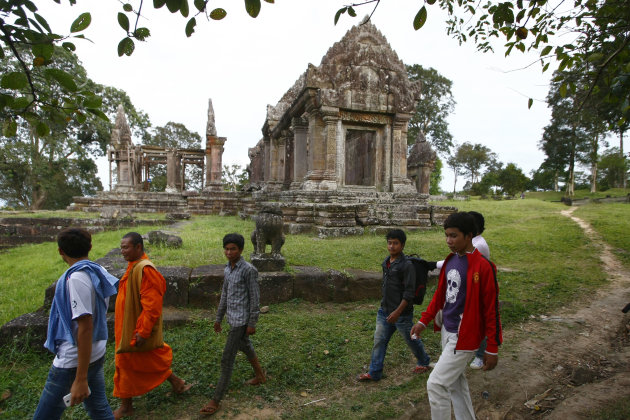 A Cambodian Buddhist monk, second from left, walks together with local tourists through the famed Preah Vihear temple near Cambodia-Thai border in Preah Vihear Province, Cambodia, Sunday, Nov. 10, 2013. The International Court of Justice rules on a dispute between Cambodia and Thailand over land surrounding the 1,000-year-old temple on Monday. (AP Photo/Heng Sinith)