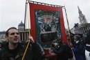 A man carries banner representing National Union of Mineworkers through crowd at party to celebrate death of late former British PM Margaret Thatcher in London