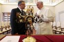 Pope Francis speaks with El Salvador's President Funes after receiving the gift of a cross from him during a meeting at the Vatican