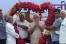 Opposition Bharatiya Janata Party (BJP) leader and India's next prime minister Narendra Modi receives a giant floral garland from supporters after his landslide victory in Vadodara, in the western Indian state of Gujarat, Friday, May 16, 2014. Modi will be India's next prime minister, winning the most decisive victory the country has seen in more than a quarter century and sweeping the long-dominant Congress party from power, partial results showed Friday. (AP Photo/ Dharmesh Jobanputra)