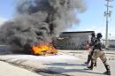Haitian policemen extinguish a fire set by protestors on November 29, 2013 in Port-au-Prince
