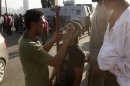 An opponent of deposed President Mursi, dresses wound of another injured in Monday's clashes with pro-Mursi protesters in Cairo