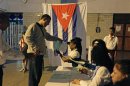 An election official gives a man ballot papers at a special polling station set up in Havana's main train station