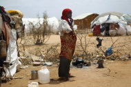 Faqid Nur Elmi's poses outside her hut in Dagahaley refugee camp north of Dadaab, Eastern Kenya, 100 kms (60 miles) from the Somali border, Thursday Aug. 11, 2011. When her 3-year-old son succumbed to hunger and thirst while fleeing Somalia's famine, she could only surround his body with small dried branches to serve as his grave. She couldn't stop to mourn _ there were five other children to think about. The United Nations warned Wednesday that the famine in East Africa hasn't peaked and hundreds of thousands of people face imminent starvation and death without a massive global response.About 1,300 new refugees arrive each day in Dadaab camps in northeastern Kenya. The new influx are running away from a famine that is getting worse in southern Somalia as an al-Qaida-linked militants in the country barred some major aid groups from operating in its areas of control, worsening the situation of the most vulnerable people. (AP Photo/Jerome Delay)