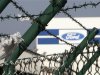 The logo of Ford Motor Company is seen between barbed wire at the Ford assembly plant in Genk
