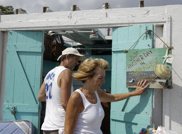 Bill Ryan watches as his wife Janet hangs up a picture in front of their roofless cabana at the Breezy Point Surf Club in the Queens section of New York, Saturday, Sept. 8, 2012, after severe weather passed the area. A tornado swept out of the sea and hit the beachfront neighborhood in New York City, hurling debris in the air, knocking out power and startling residents who once thought of twisters as a Midwestern phenomenon. Firefighters were still assessing the damage, but no serious injuries were reported and the area affected by the storm appeared small. (AP Photo/Kathy Willens)