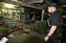 Thai security personnel inspect a grocer's shop where six people were shot dead by suspected Muslim militants in the southern province of Pattani
